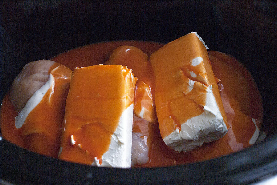 ingredients for buffalo chicken dip added to crockpot