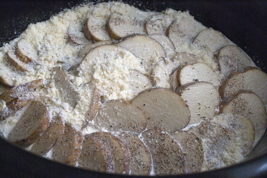 sliced potatoes covered in parmesan cheese and heavy cream 